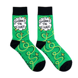 A pair of socks standing against a white background. The socks are green and gold and read Embrace The Chaos. 