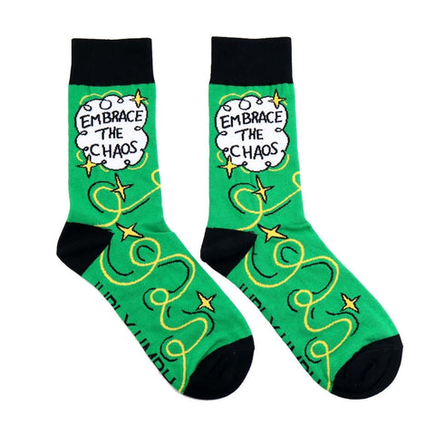 A pair of socks standing against a white background. The socks are green and gold and read Embrace The Chaos. 