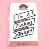 An iron on embroidered patch is being displayed on Jubly-Umph card stock. The patch reads I'm A Fucking Delight.